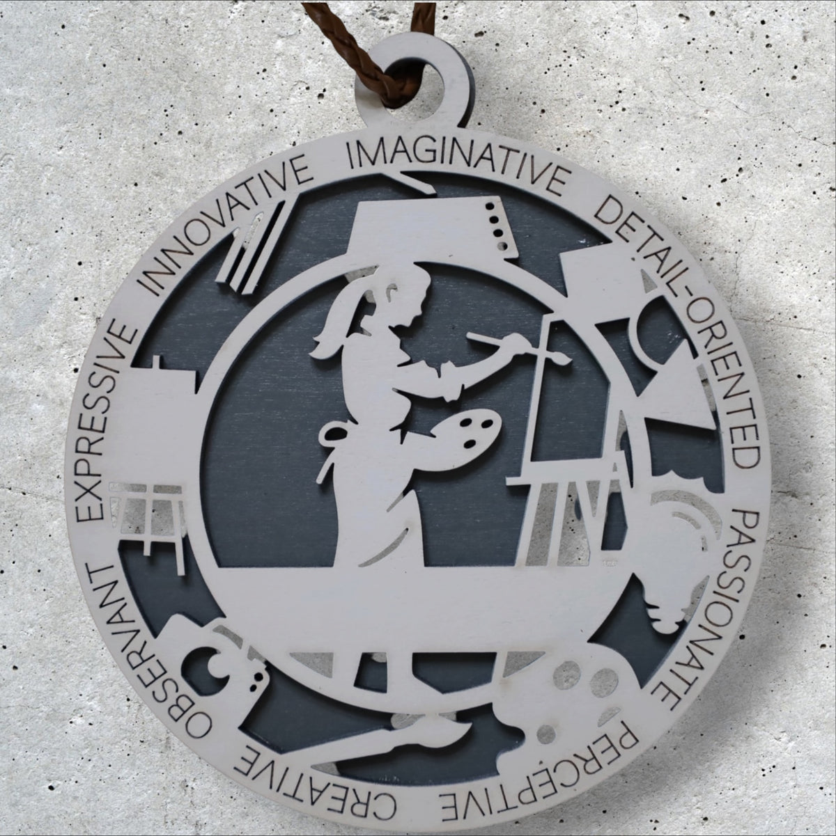 Artist Christmas ornament by Trail and Timber Co. — laser-cut wood, ringed with the words innovative, imaginative, detail-oriented