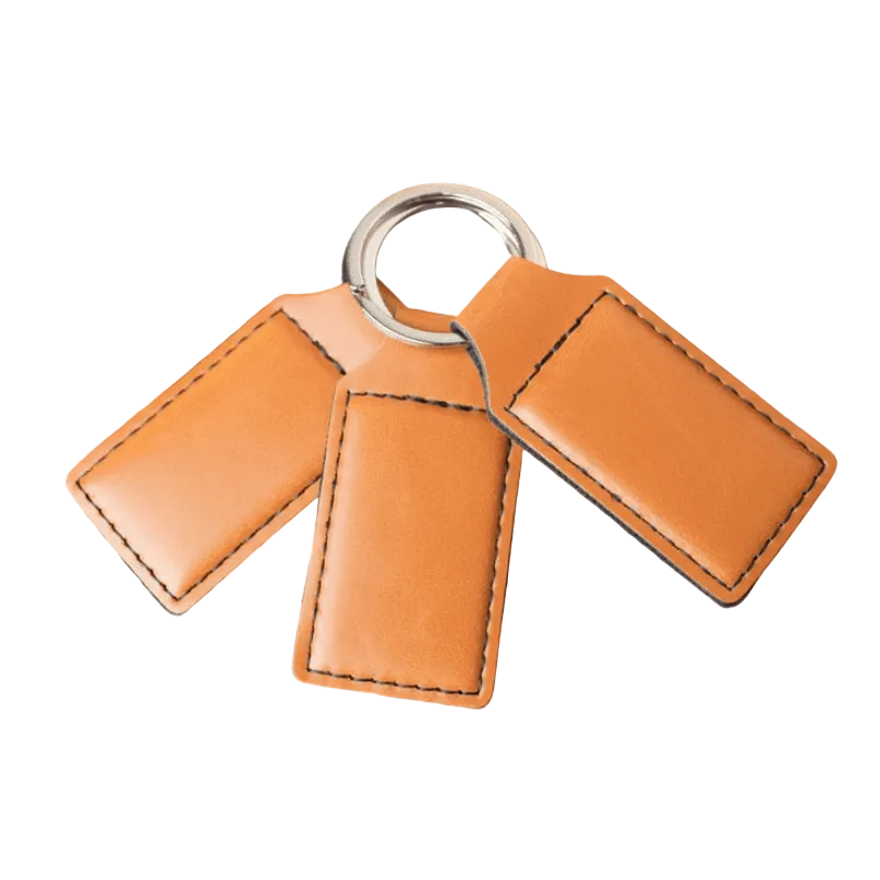 Three buckskin leatherette keychain tags on a split ring, white background