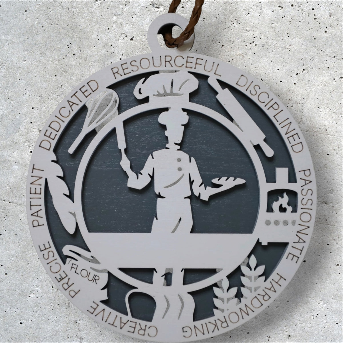 Chef Christmas ornament by Trail and Timber Co. — laser-cut wood, ringed with the words dedicated, disciplined, passionate, precise